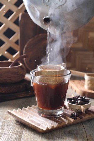 Foto de Coffee cup with hot chocolate and cinnamon sticks on wooden table - Imagen libre de derechos