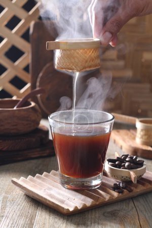 Photo for Pouring coffee with a cup of tea and a glass of hot chocolate on a wooden background - Royalty Free Image