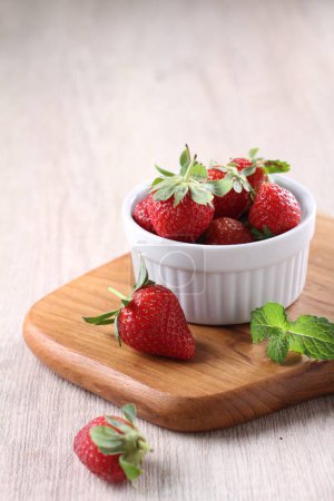 Photo for Fresh strawberries in a bowl on a wooden background - Royalty Free Image