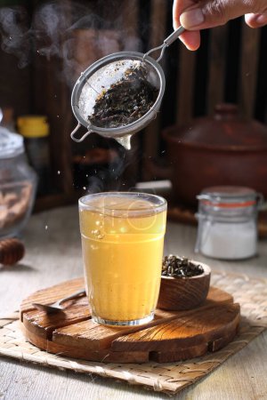 Foto de Tea cup with fresh mint in a glass jar on a wooden background - Imagen libre de derechos