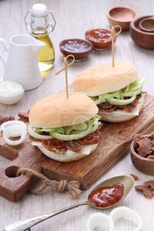 Téléchargez les photos : Le hamburger ou les hamburgers peuvent faire référence à : Hamburger, un sandwich composé d'une ou plusieurs galettes de boeuf cuites, placé à l'intérieur d'un pain ou d'un pain en tranches. - en image libre de droit
