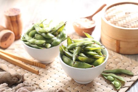 Foto de Edamame is Japanese dish and prepared of immature soybeans in the pod. The pods are boiled or steamed and may be served with salt or other condiments. Nowadays it became to be so popular in the world - Imagen libre de derechos