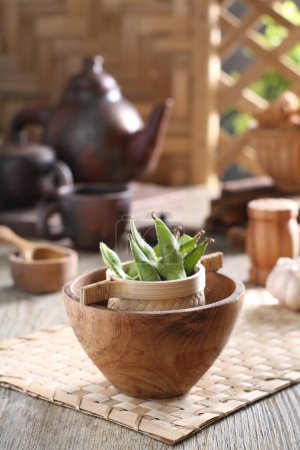 Téléchargez les photos : Bowl of green beans and pestle on wooden table - en image libre de droit
