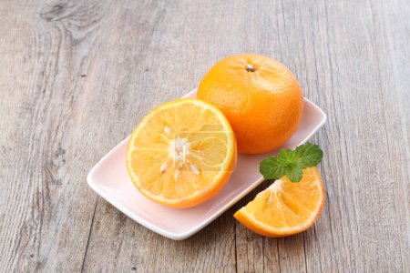 Téléchargez les photos : Fresh orange fruit and mint in a white dish on an old background. - en image libre de droit