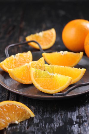 Téléchargez les photos : Sliced oranges with slices, on a black wooden background, close up - en image libre de droit