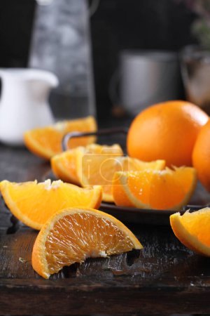Foto de Sliced oranges and slices of orange on wooden cutting board, selective focus. healthy food and drink concept. - Imagen libre de derechos