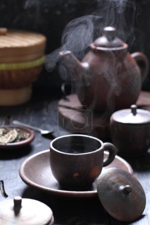 Téléchargez les photos : Le thé est une boisson aromatique préparée en versant de l'eau chaude ou bouillante sur des feuilles séchées ou fraîches de Camellia sinensis, un arbuste à feuilles persistantes originaire d'Asie de l'Est qui est probablement originaire des régions frontalières du sud-ouest de la Chine et du nord du Myanmar.. - en image libre de droit