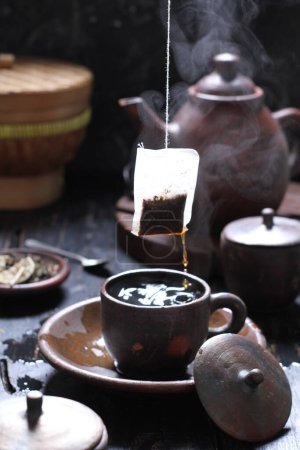 Téléchargez les photos : Le thé est une boisson aromatique préparée en versant de l'eau chaude ou bouillante sur des feuilles séchées ou fraîches de Camellia sinensis, un arbuste à feuilles persistantes originaire d'Asie de l'Est qui est probablement originaire des régions frontalières du sud-ouest de la Chine et du nord du Myanmar.. - en image libre de droit
