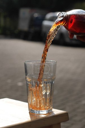 Téléchargez les photos : Pouring water into glass on a wooden table - en image libre de droit