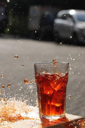 Foto de Glass of cola with ice cubes on the background of the water - Imagen libre de derechos