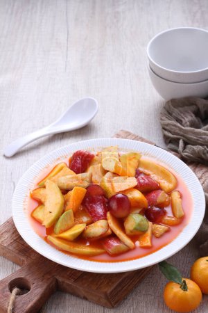 Photo for Asinan is a pickled vegetable or fruit dish, commonly found in Indonesia. Asin, Indonesian for "salty", is the process of preserving the ingredients by soaking them in a solution of salty water. Asinan is quite similar to rujak', - Royalty Free Image