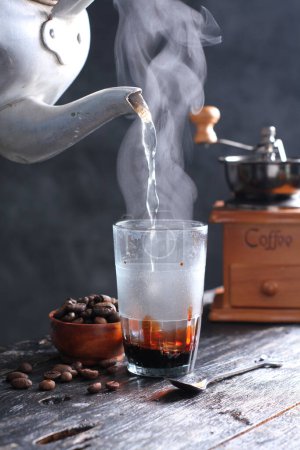 Téléchargez les photos : Kopi Tubruk est un café de style indonésien où l'eau chaude est versée sur de fins marcs de café directement dans le verre, sans aucune filtration, généralement avec du sucre ajouté. - en image libre de droit