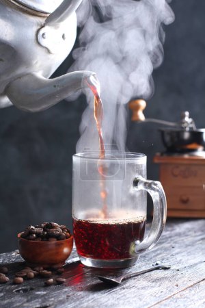 Téléchargez les photos : Kopi Tubruk est un café de style indonésien où l'eau chaude est versée sur de fins marcs de café directement dans le verre, sans aucune filtration, généralement avec du sucre ajouté. À Bali, Kopi Tubruk est connu sous le nom de "Kopi Selem" qui signifie café noir. - en image libre de droit
