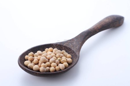 Foto de Haba de soja en una cuchara de madera sobre fondo blanco - Imagen libre de derechos