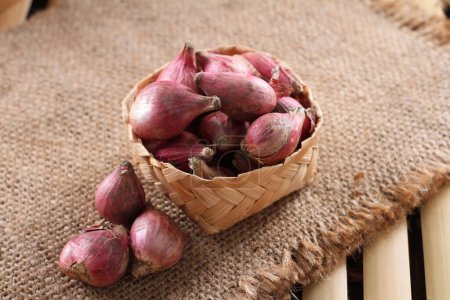Photo for Fresh red onion in a basket on a wooden background - Royalty Free Image
