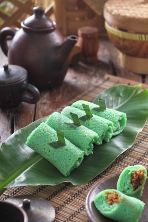 Photo for Dadar gulung (lit:"rolled pancake/omelette") is a popular traditional kue (traditional snack) of sweet coconut pancake. It is often described as an Indonesian coconut pancake Dadar gulung is one of the popular snacks in Indonesia, especially in Java. - Royalty Free Image