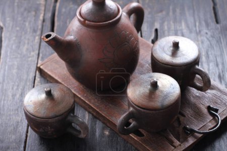 Photo for Ceramic teapot with old kettle and a cup on a wooden background. - Royalty Free Image