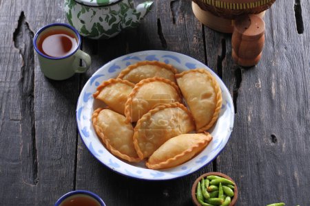 Téléchargez les photos : Le Jalangkote est une boulette frite de Sulawesi du Sud de la cuisine indonésienne, farcie de vermicelles de riz, de légumes, de pommes de terre et d'œufs. Sauce épicée, sucrée et aigre sera trempé dans avant d'être mangé. - en image libre de droit
