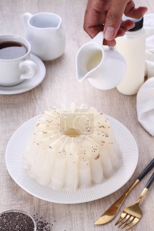 Téléchargez les photos : Gros plan d'une tasse de thé blanc avec crème et une soucoupe - en image libre de droit