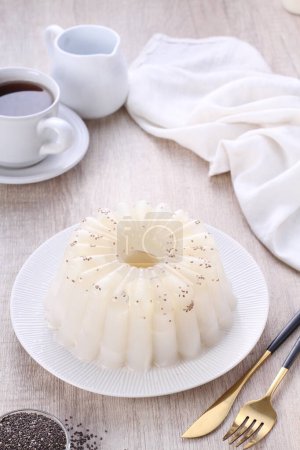 Foto de Pastel de té blanco con crema y una taza de café sobre un fondo de madera - Imagen libre de derechos
