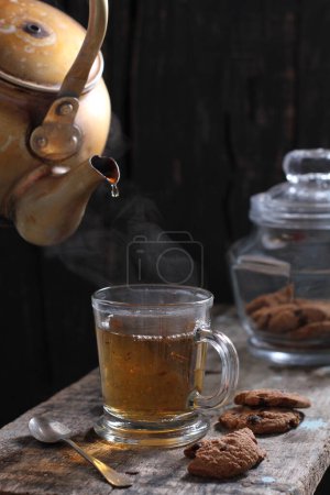 Téléchargez les photos : Tea is an aromatic beverage prepared by pouring hot or boiling water over cured or fresh leaves of Camellia sinensis, an evergreen shrub native to East Asia which probably originated in the borderlands of southwestern China and northern Myanmar. - en image libre de droit