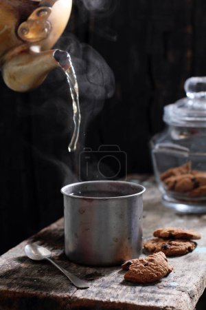 Photo for Tea is an aromatic beverage prepared by pouring hot or boiling water over cured or fresh leaves of Camellia sinensis, an evergreen shrub native to East Asia which probably originated in the borderlands of southwestern China and northern Myanmar. - Royalty Free Image