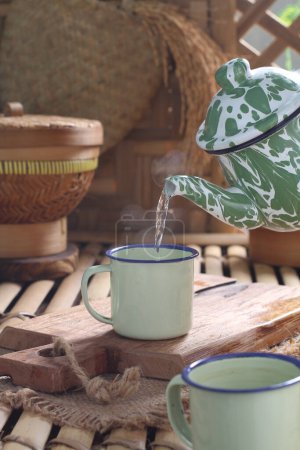 Téléchargez les photos : Tea is an aromatic beverage prepared by pouring hot or boiling water over cured or fresh leaves of Camellia sinensis, an evergreen shrub native to East Asia which probably originated in the borderlands of southwestern China and northern Myanmar. - en image libre de droit