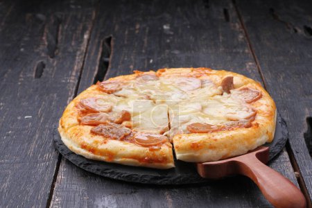 Téléchargez les photos : La pizza est un plat d'origine italienne composé d'une base généralement ronde et plate de pâte à base de blé levé garnie de tomates, de fromage et souvent d'autres ingrédients. - en image libre de droit