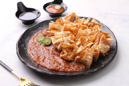 Téléchargez les photos : Batagor est un plat sundanais d'Indonésie, et populaire en Asie du Sud-Est, composé de boulettes de poisson frit, généralement servi avec de la sauce aux arachides. Il est traditionnellement fabriqué à partir de tenggiri haché - en image libre de droit
