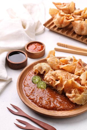 Photo for Batagor  is a Sundanese dish from Indonesia, and popular in Southeast Asia, consisting of fried fish dumplings, usually served with peanut sauce. It is traditionally made from minced tenggiri, - Royalty Free Image