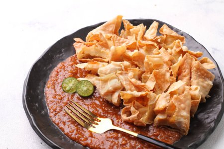 Téléchargez les photos : Batagor est un plat sundanais d'Indonésie, et populaire en Asie du Sud-Est, composé de boulettes de poisson frit, généralement servi avec de la sauce aux arachides. Il est traditionnellement fabriqué à partir de tenggiri haché, - en image libre de droit