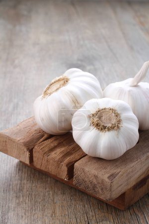Photo for Garlic on wooden board on table - Royalty Free Image
