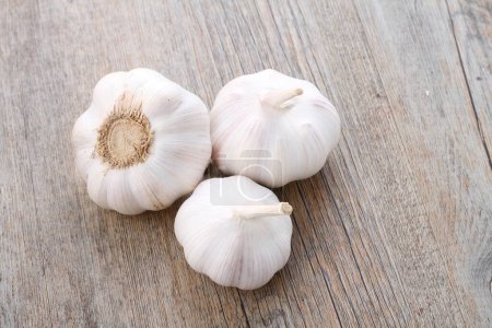 Photo for Garlic cloves in the white bowl on wooden table - Royalty Free Image