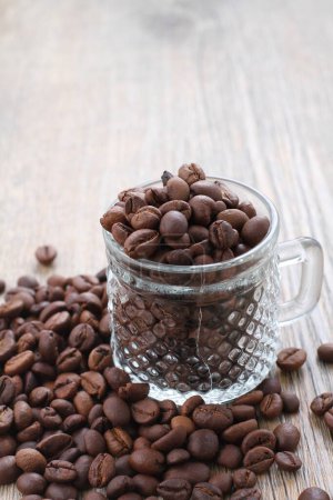 Téléchargez les photos : Grains de café dans une tasse sur un fond en bois - en image libre de droit