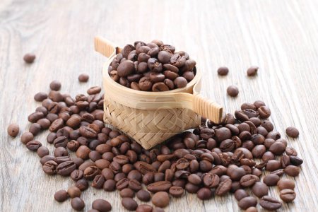 Photo for Coffee beans in a wooden cup on burlap sack background - Royalty Free Image