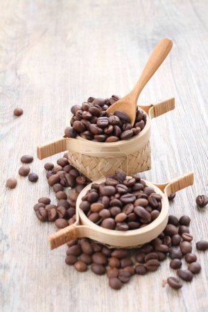 Téléchargez les photos : Grains de café brun et cuillère en bois avec fond en bois. - en image libre de droit