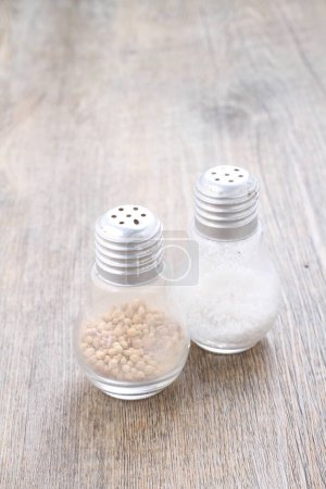 Photo for White pepper and salt shaker, on a wooden background. - Royalty Free Image