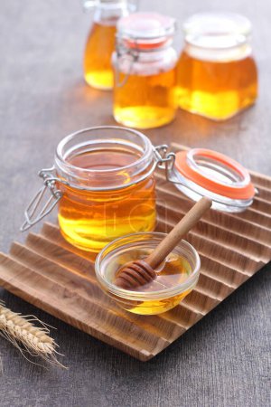 Foto de Tarro de miel fresca en frascos de vidrio sobre fondo de madera - Imagen libre de derechos