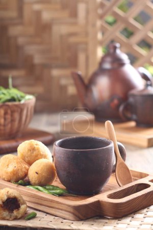 Photo for Dinner table situation in the morning, a cup of hot tea with combro cake - Royalty Free Image