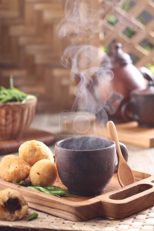 Photo for Dinner table situation in the morning, a cup of hot tea with combro cake - Royalty Free Image