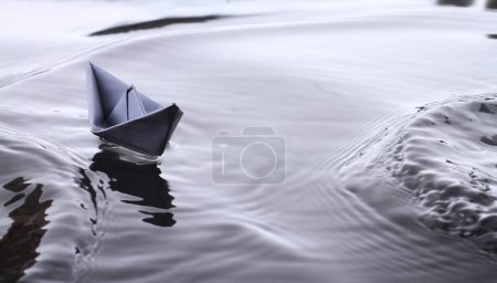 Photo for Paper boat on the bumpy surface of the water - Royalty Free Image