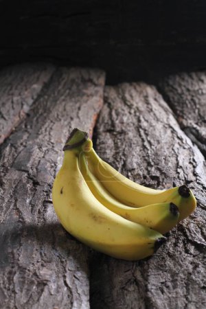 Foto de Plátanos maduros en la mesa de corteza - Imagen libre de derechos