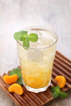 Photo for Ice fresh orange with mint leaf garnish - Royalty Free Image