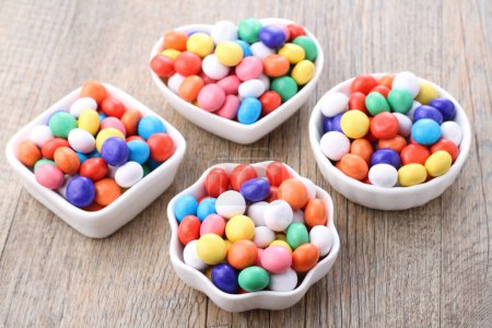 Foto de Caramelos de azúcar de colores en la mesa de madera - Imagen libre de derechos