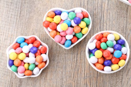 Téléchargez les photos : Bonbons colorés sur fond en bois - en image libre de droit