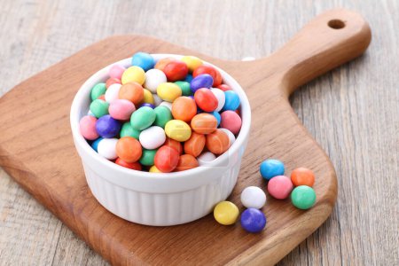 Foto de Colorful candies in a bowl on a wooden background - Imagen libre de derechos