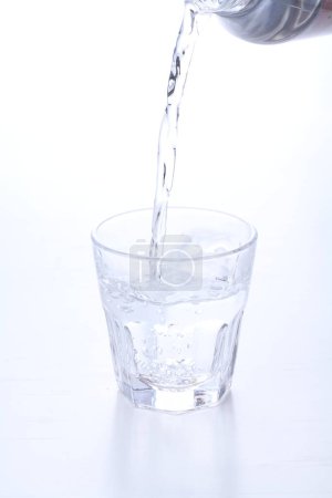 Foto de Verter agua en vidrio sobre fondo blanco - Imagen libre de derechos