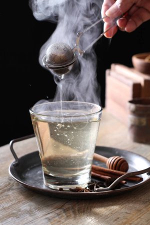 Photo for Tea is an aromatic beverage prepared by pouring hot or boiling water over cured or fresh leaves of Camellia sinensis, an evergreen shrub native to East Asia which probably originated in the borderlands of southwestern China - Royalty Free Image