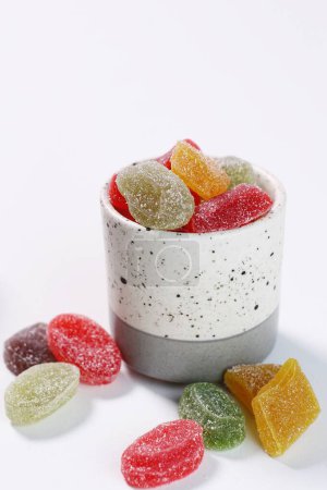 Foto de Caramelos de colores en un tazón de vidrio sobre fondo blanco - Imagen libre de derechos