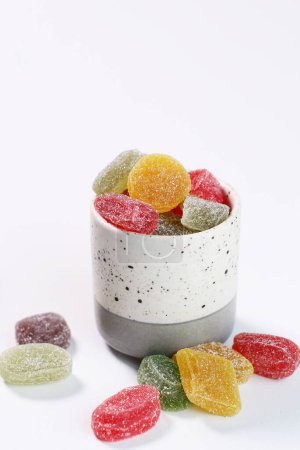 Téléchargez les photos : Bonbons colorés dans un bol sur fond blanc, gros plan, mise au point sélective - en image libre de droit